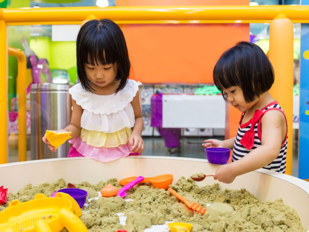 Girls playing kinetic sand at Sandbox Interactive Children’s Museum