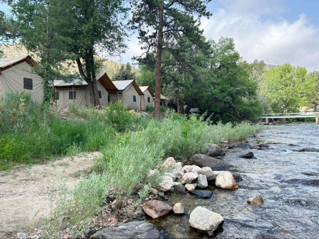 View of the riverside glamping tents surrounded by greenery