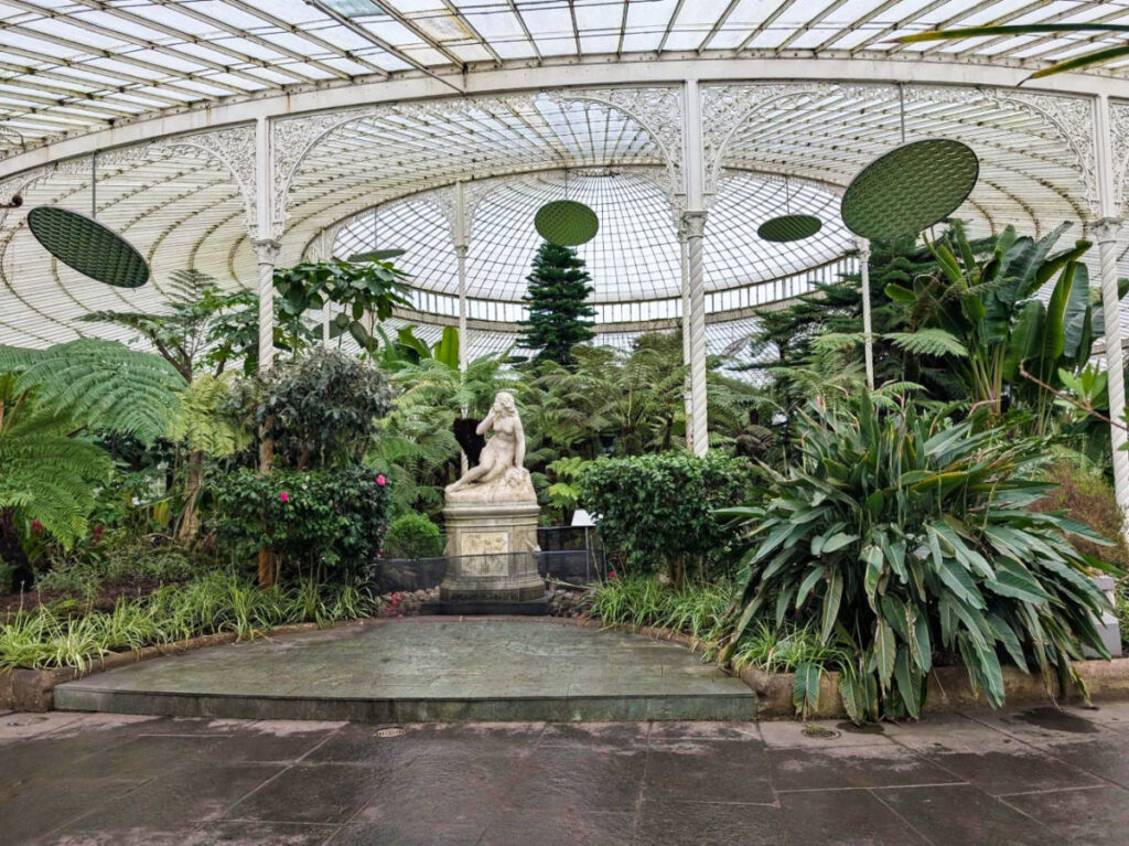 A statue in the middle of the greenery in the Kibble Palace