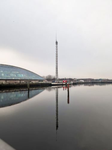 A closer look of the Glasgow Tower reflecting on the water on a gloomy day