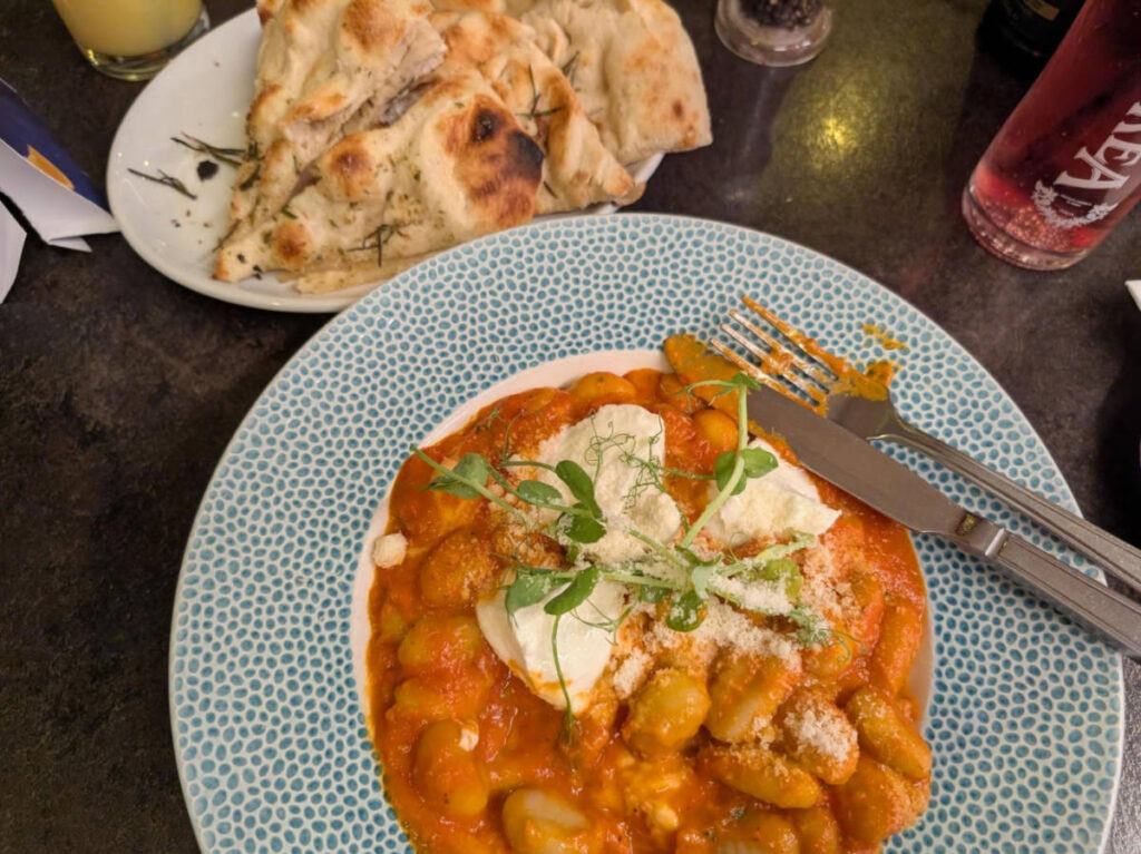 A plate with gnocchi al forno and focaccia
