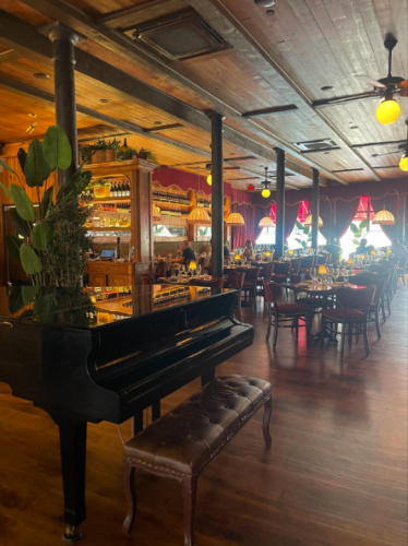 View of the grand piano in the main room of Capri Boston