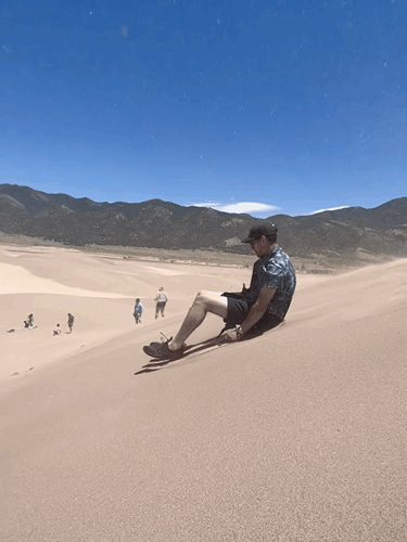 A man trying the sand sled at Great Sand Dunes National Park