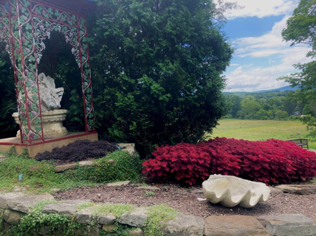 A gazebo surrounded by green and red plants at the grounds of Naumkeag