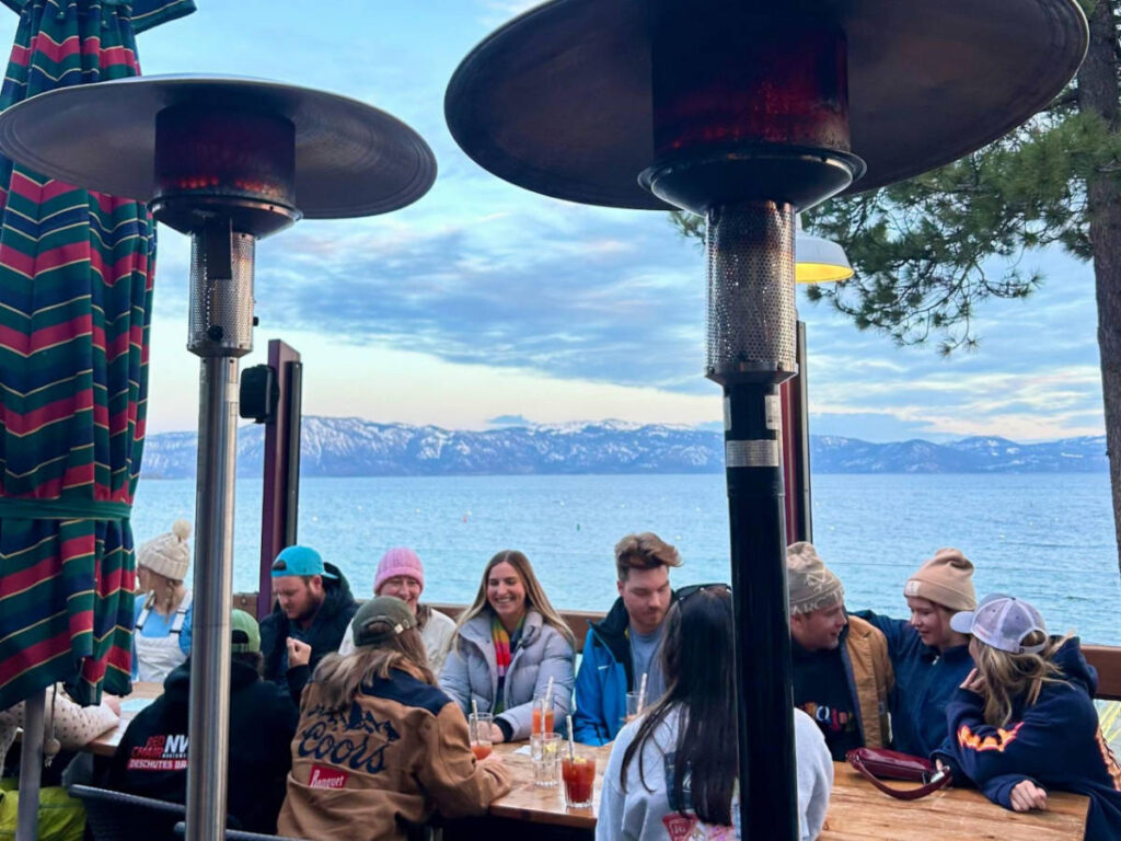 A group of friends enjoying at the outdoor table with excellent views of the lake