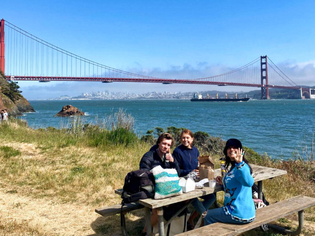 The author Laura McFarland's friends on a picnic table at the Kirby Cove campground with the Golden Gate Bridge in the background