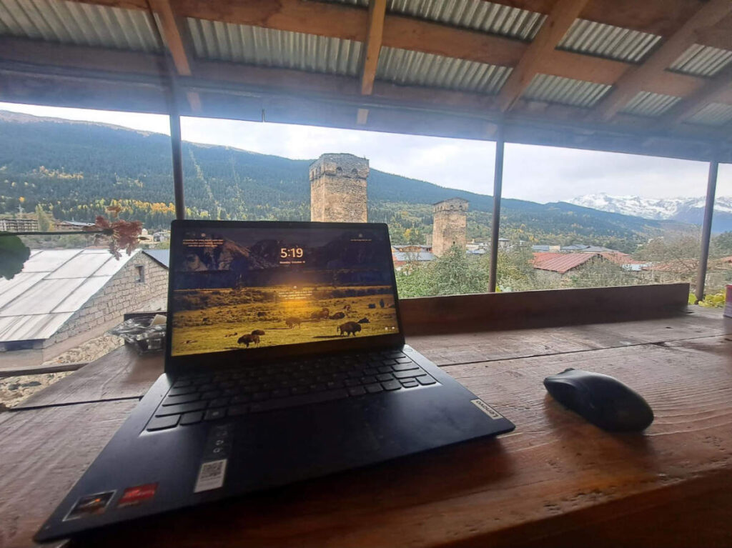 A laptop on a table in Guesthouse Chela with an overlooking view