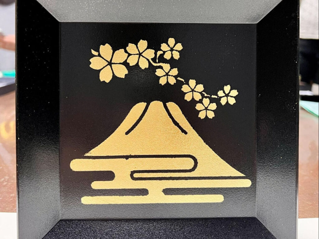 A plate decorated with gold Mt. Fuji and Sakura icons made at Hakuza Keikodokoro