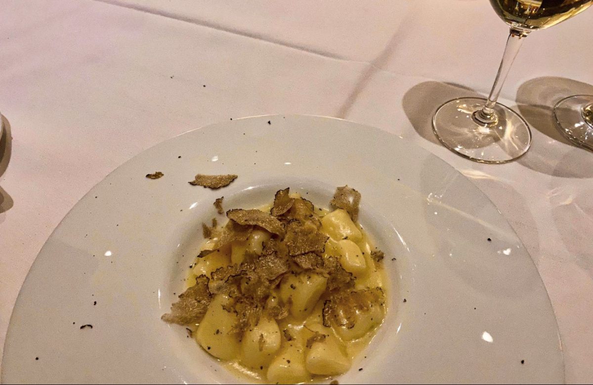 Closeup view of the handmade truffle gnocchi with a glass of wine