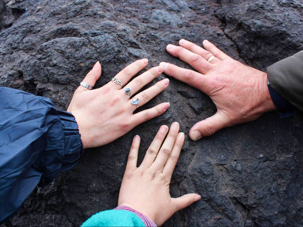 The hands touching the lava rock