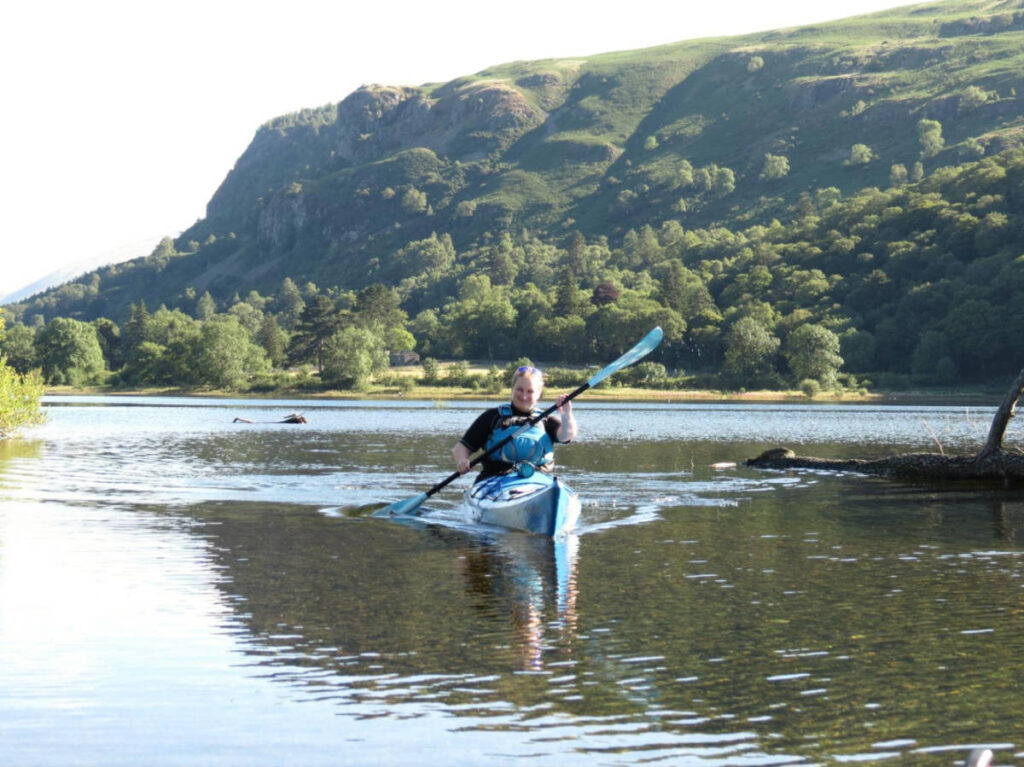 The author Heather Cole, kayaking on Derwentwater surrounded by mountain views