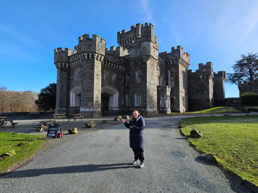 The author Heather Cole, posing for a photo in front of the Wray Castle