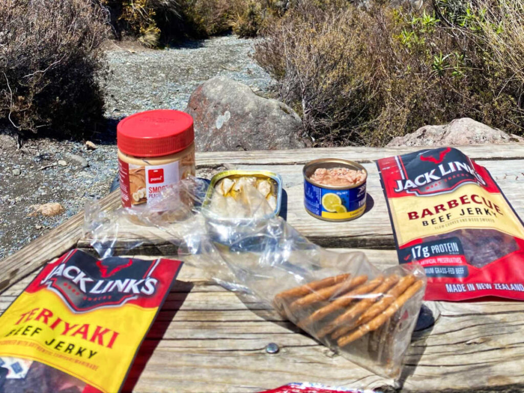 A wooden table with a variety of high-protein snacks