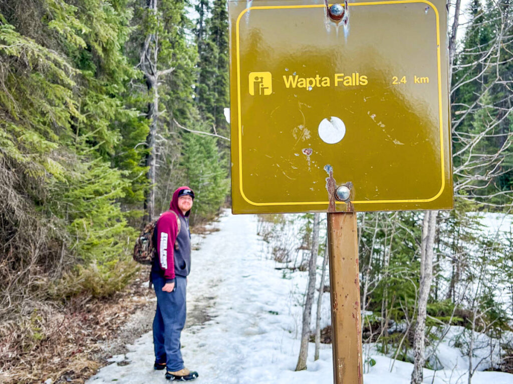 A man on the trail with Wapta Falls sign