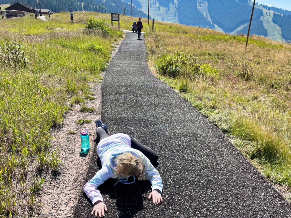 The author Laura Falin lying on the cemented trail