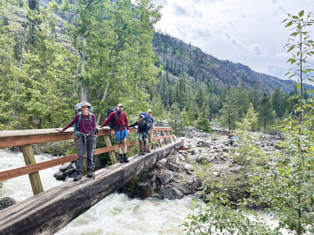 The author Chelsea Booker and her family crossing the wooden bridge