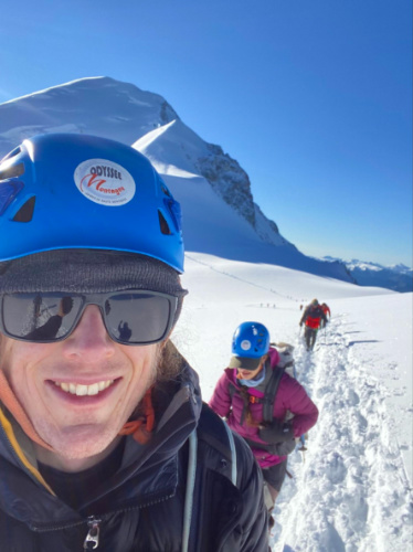 A man with a helmet and sunglasses hiking on Mont Blanc Mountain
