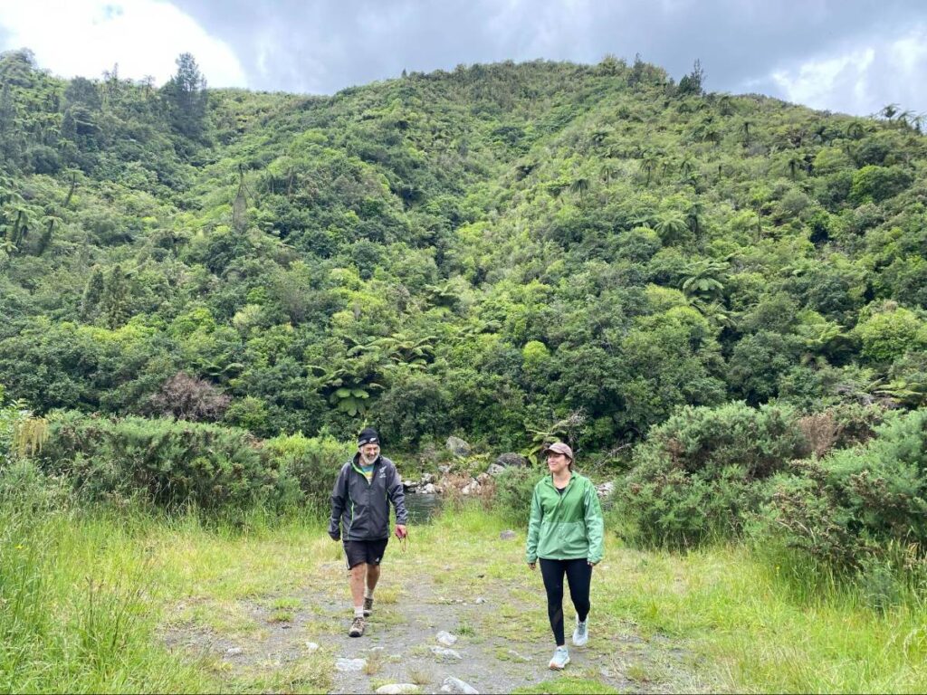 Author's partner and homestay host hiking through the New Zealand woods