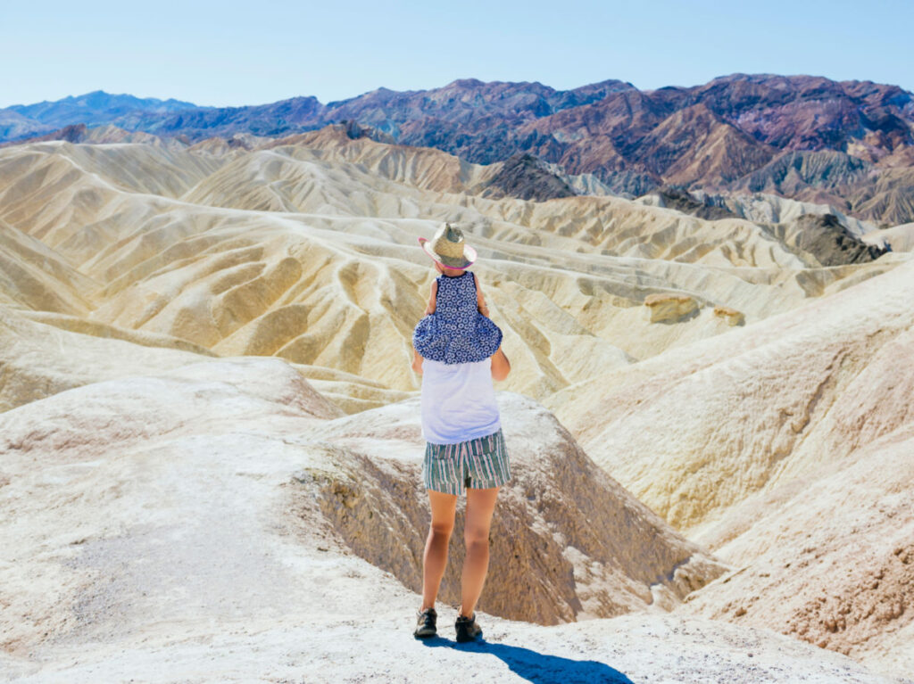 Back view of a mother carrying baby girl at Death Valley National Park