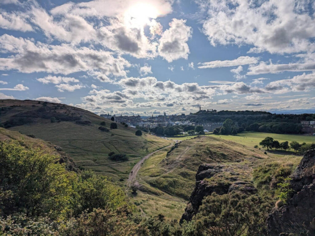 Panoramic view of the green landscape and skyline of Edinburgh on a sunny day