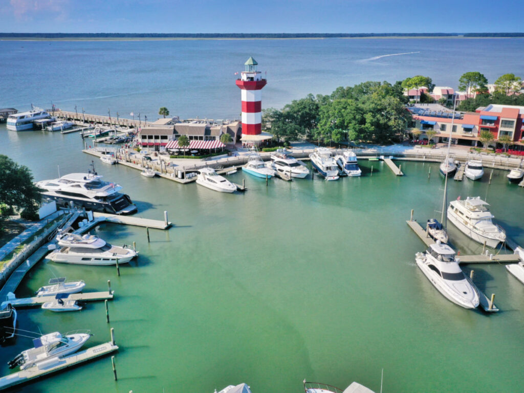 Aerial view of boats moored in the marina and a lighthouse on the pier