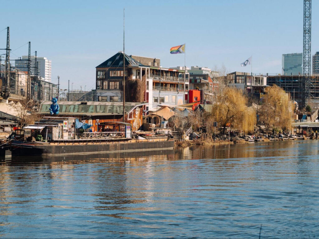 Panoramic view of the Holzmarkt 25 and the fall foliage seen from across the water