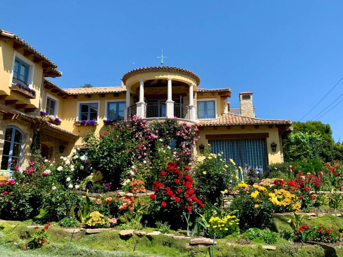 A beautiful house surrounded by flowers along the Manhattan Beach boardwalk