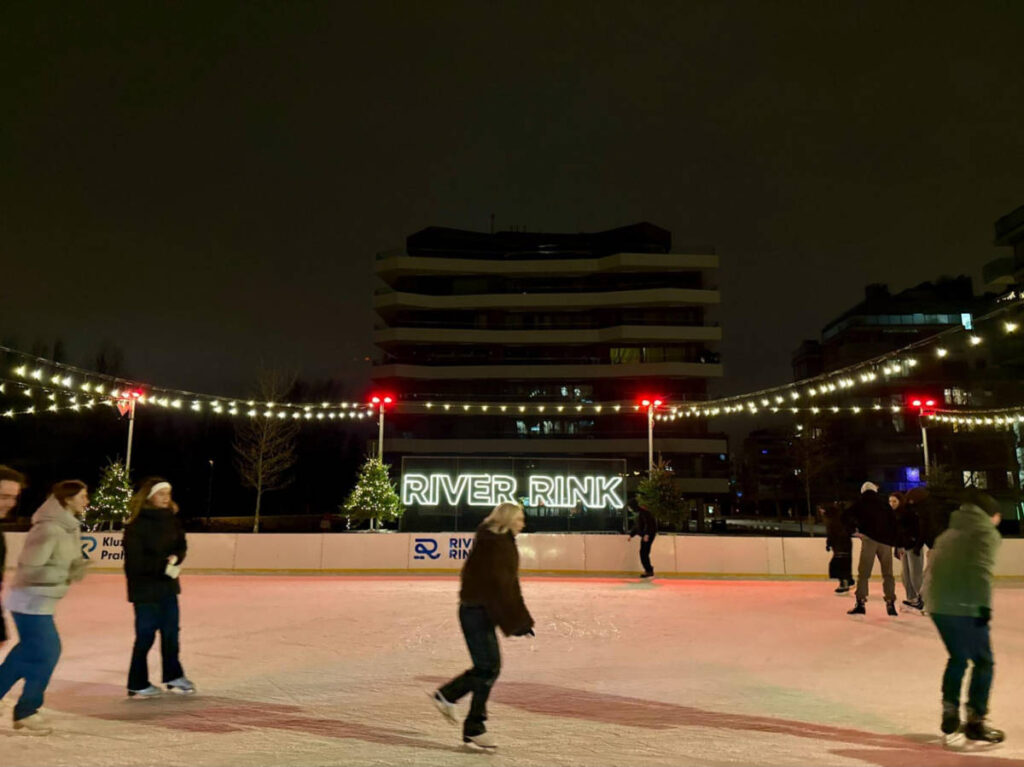 People skating on the ice rink at the River Rink at night