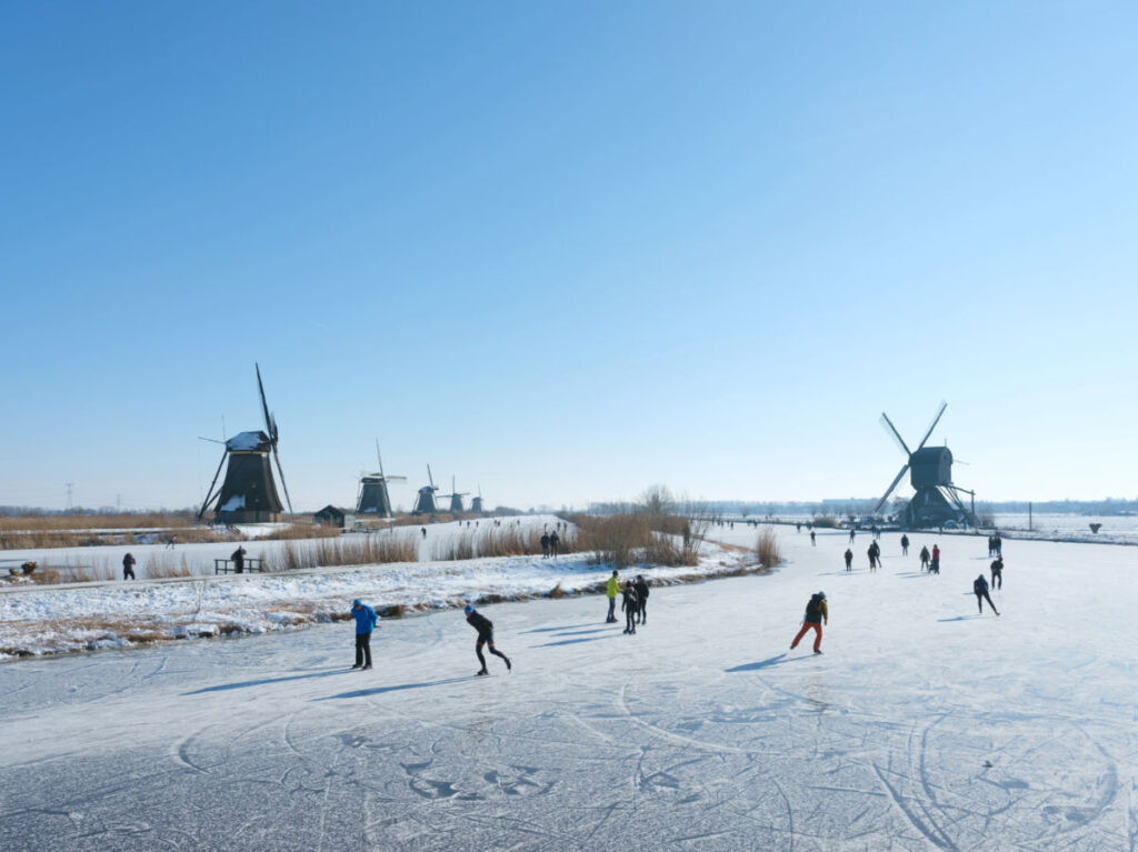 Group of people Ice skating close to the Kinderdijken