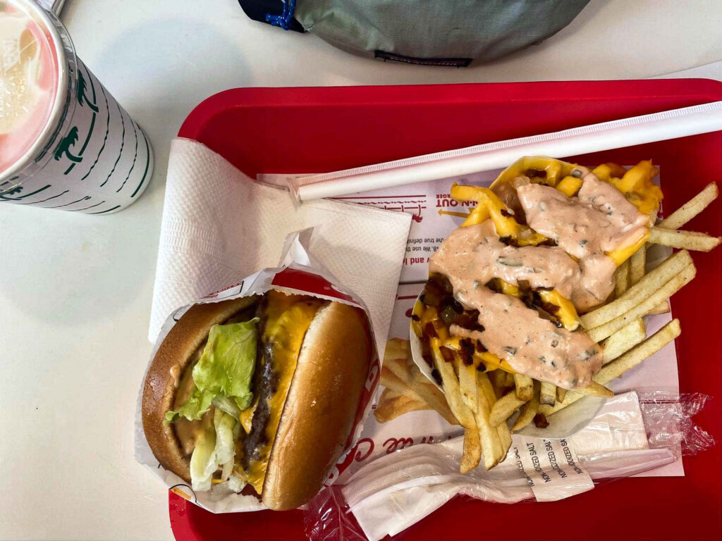 A red try with cheeseburger, animal-style fries, and a milkshake