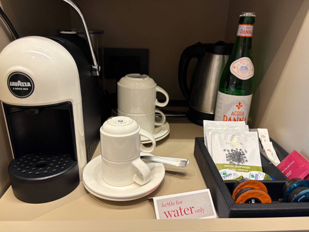 The coffee maker, pods, teas and mugs in the in-room coffee station