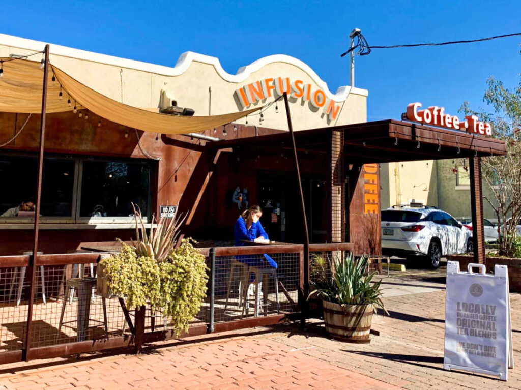 A woman chilling at the sunny patio of Infusion Coffee & Tea Crafters