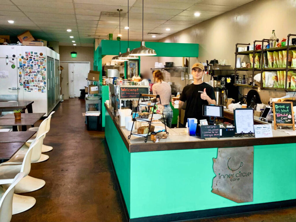 The staffs inside the cozy interior of Inner Circle Cafe featuring green walls and white chairs