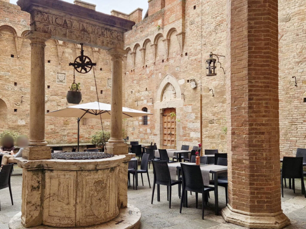 A non-working well surrounded by seats at the inner courtyard of Accademia Musicale Chigiana