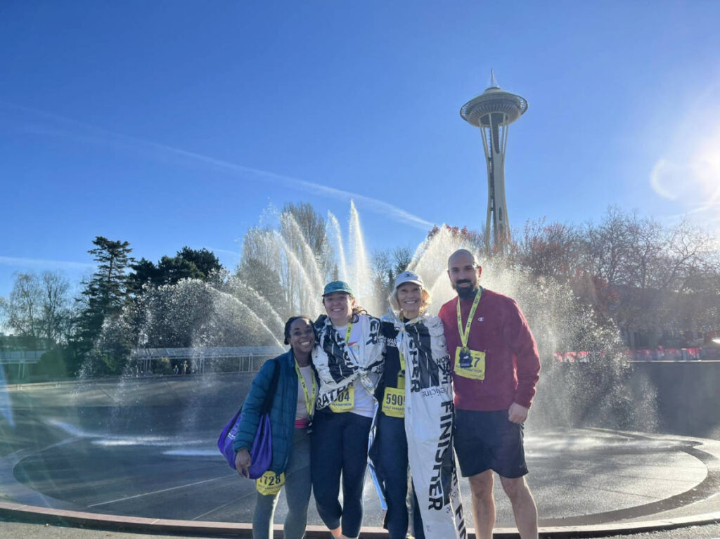 The author, Chelsea Booker with her husband and in-laws with the International Fountain and Space Needle on their background
