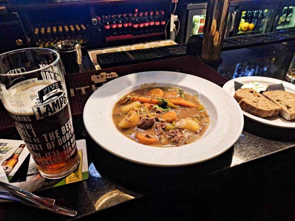 A plate of Irish stew and a glass of beer inside a pub in Dublin