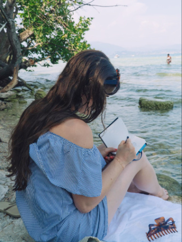 The author's friend writing on a notebook in Jamaica Beach