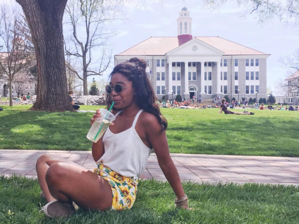The author, Alexandria Taylor sitting on the grass in James Madison University