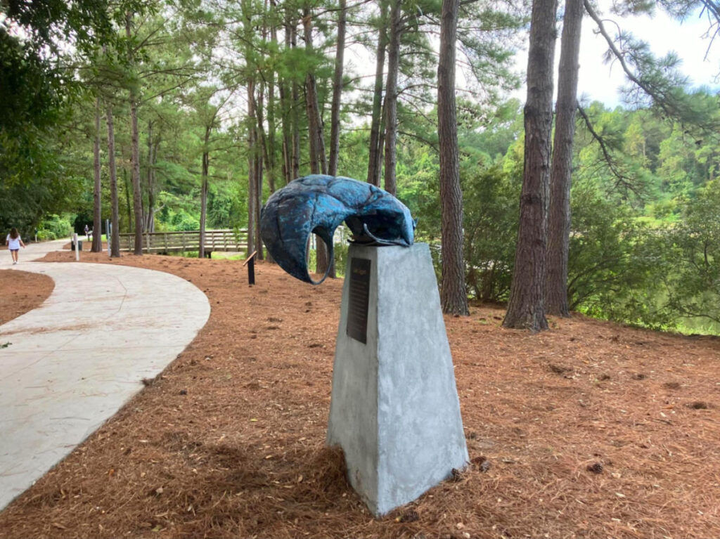 Sculpture perched on a pedestal amidst the woods at Jarvis Creek Park