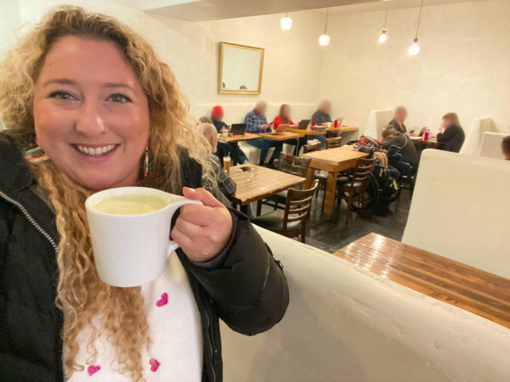 The author Jess Levy holding a cup of pecan milk latte at Betterday