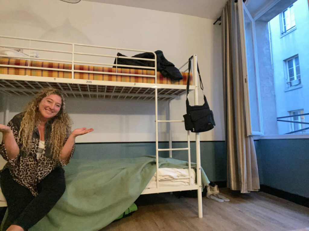 The author Jess Levy posing for a photo on a hostel in Paris