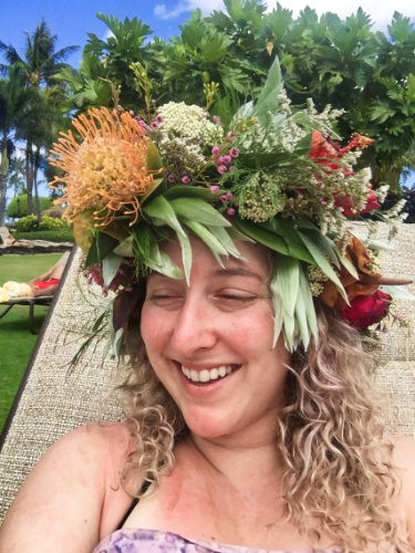 The author Jess Levy smiling for a photo while wearing a flower crown