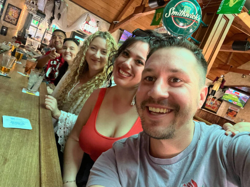 The author Jess Levy and her friends, smiling for a photo at Hennessey’s Tavern