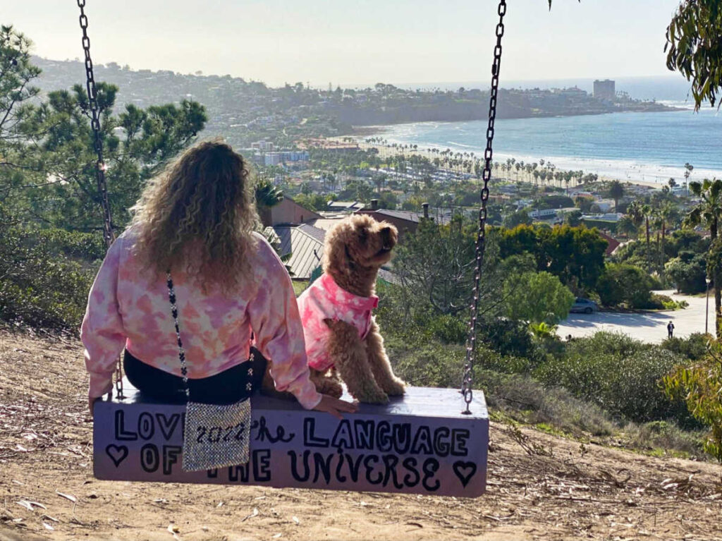 The author Jess Levy and her dog enjoying the swing with an overlooking view of La Jolla