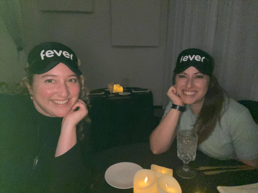 The author Jess Levy and her friend smiling for a photo while in the dark