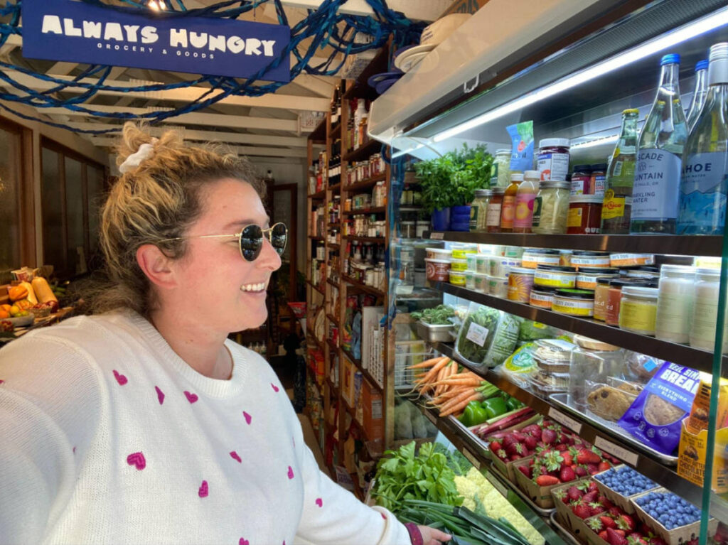 The author Jess Levy looking at the displays in Always Hungry Grocery & Goods