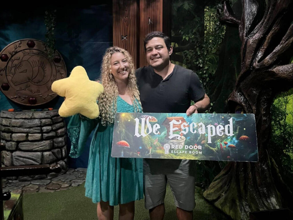 Travel Lemming author Jess and her date, posing for a photo with a We Escaped sign at the Red Door Escape Room