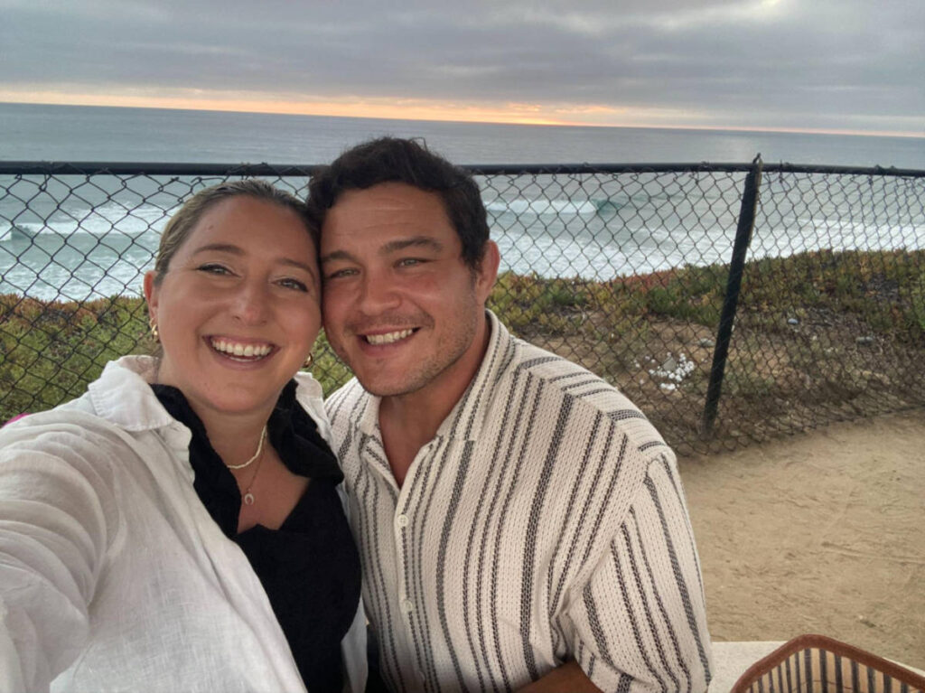 Travel Lemming author Jess and her date, smiling for a photo at The Camp Store at sunset