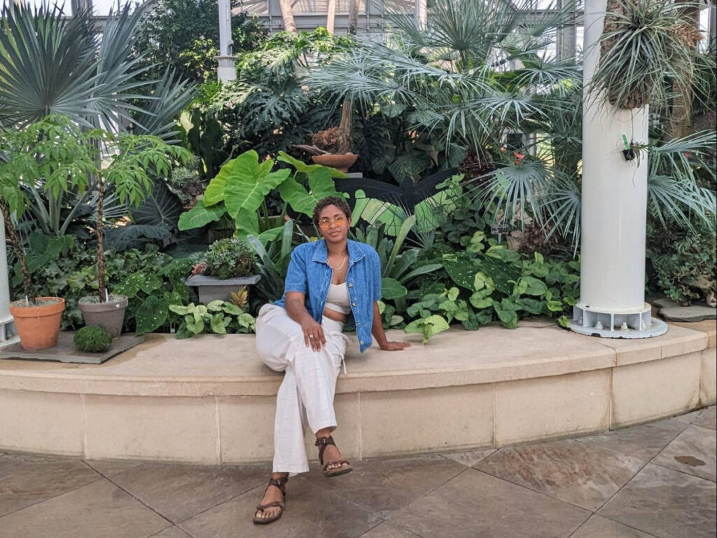 The author, Jonaye Barnum, sitting inside the Lewis Ginter Botanical Gardens