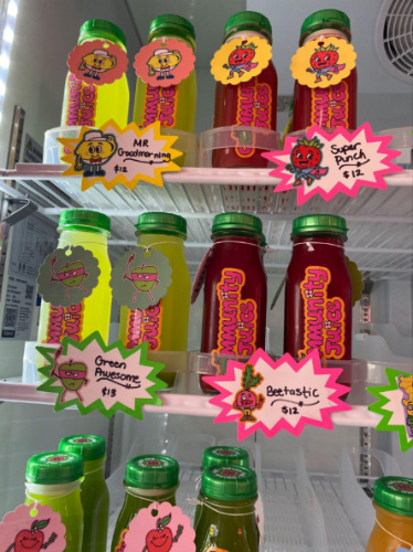 View of the colorful juices and labels inside the fridge of Community Juice